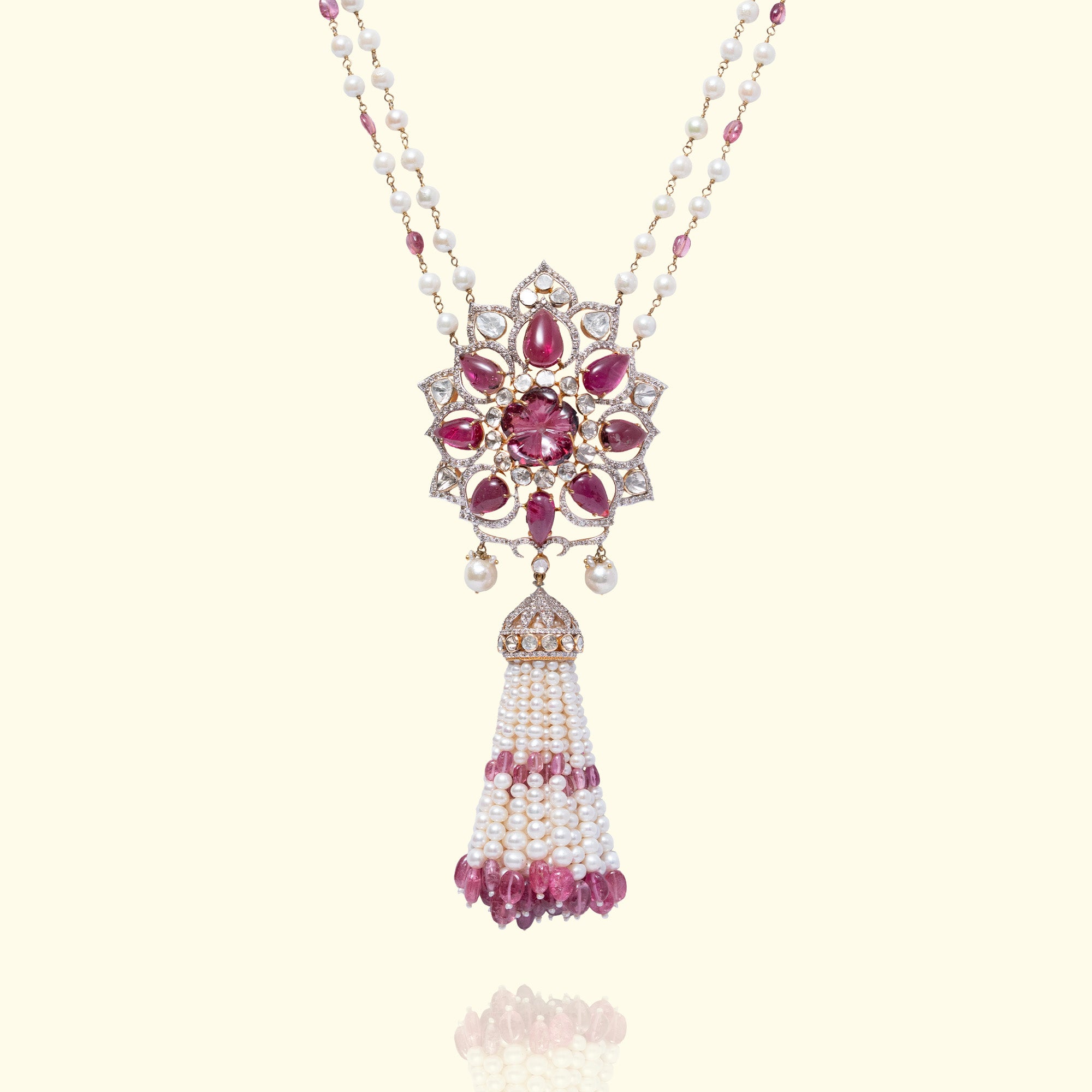 Ornate floral polki pendant necklace featuring pink tourmaline petals, uncut diamonds and a cascading white pearl tassel with pink gemstone droplets.