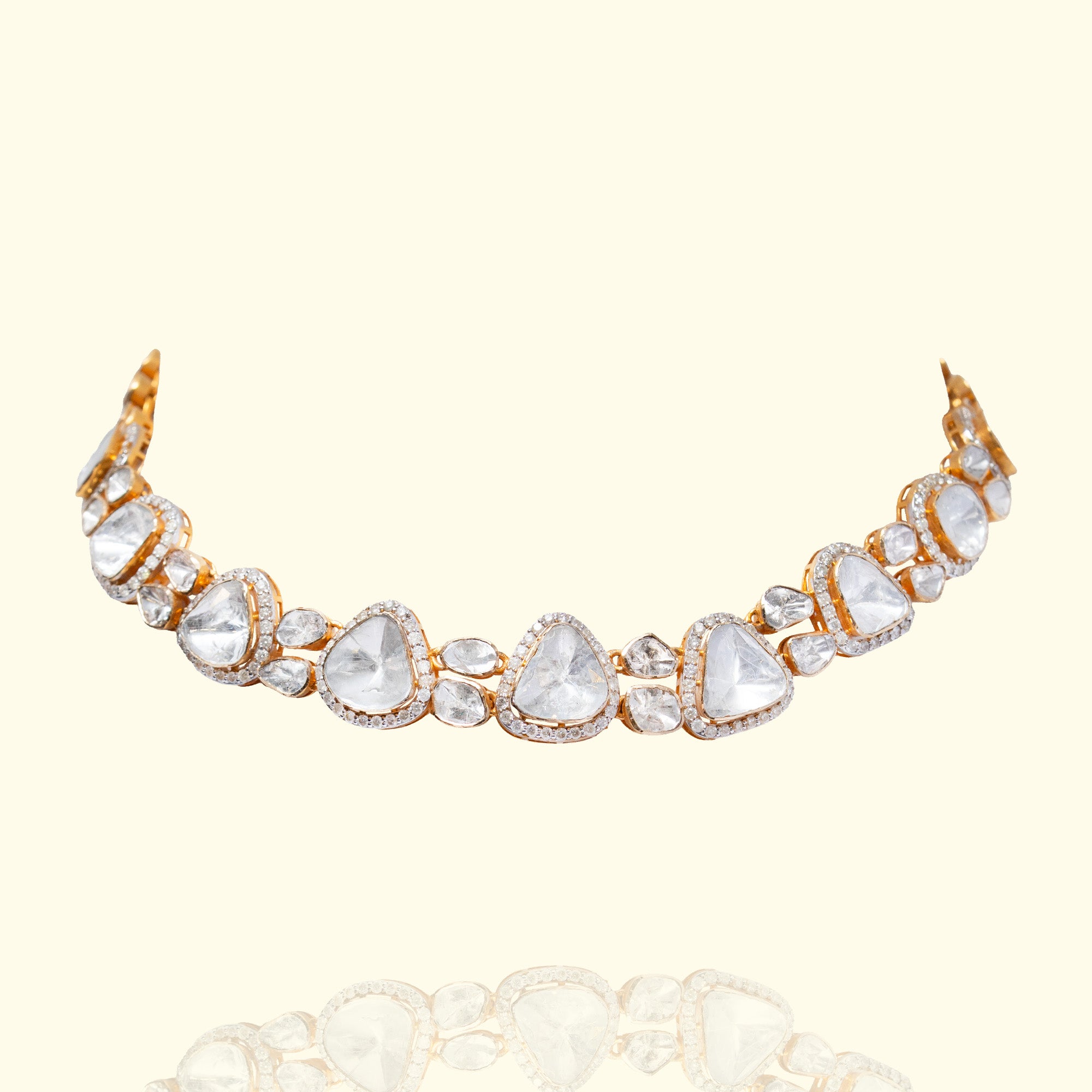 A model wearing a sophisticated gold choker necklace featuring a graduating sequence of triangle-cut polki diamonds in individual diamond-pavé frames.