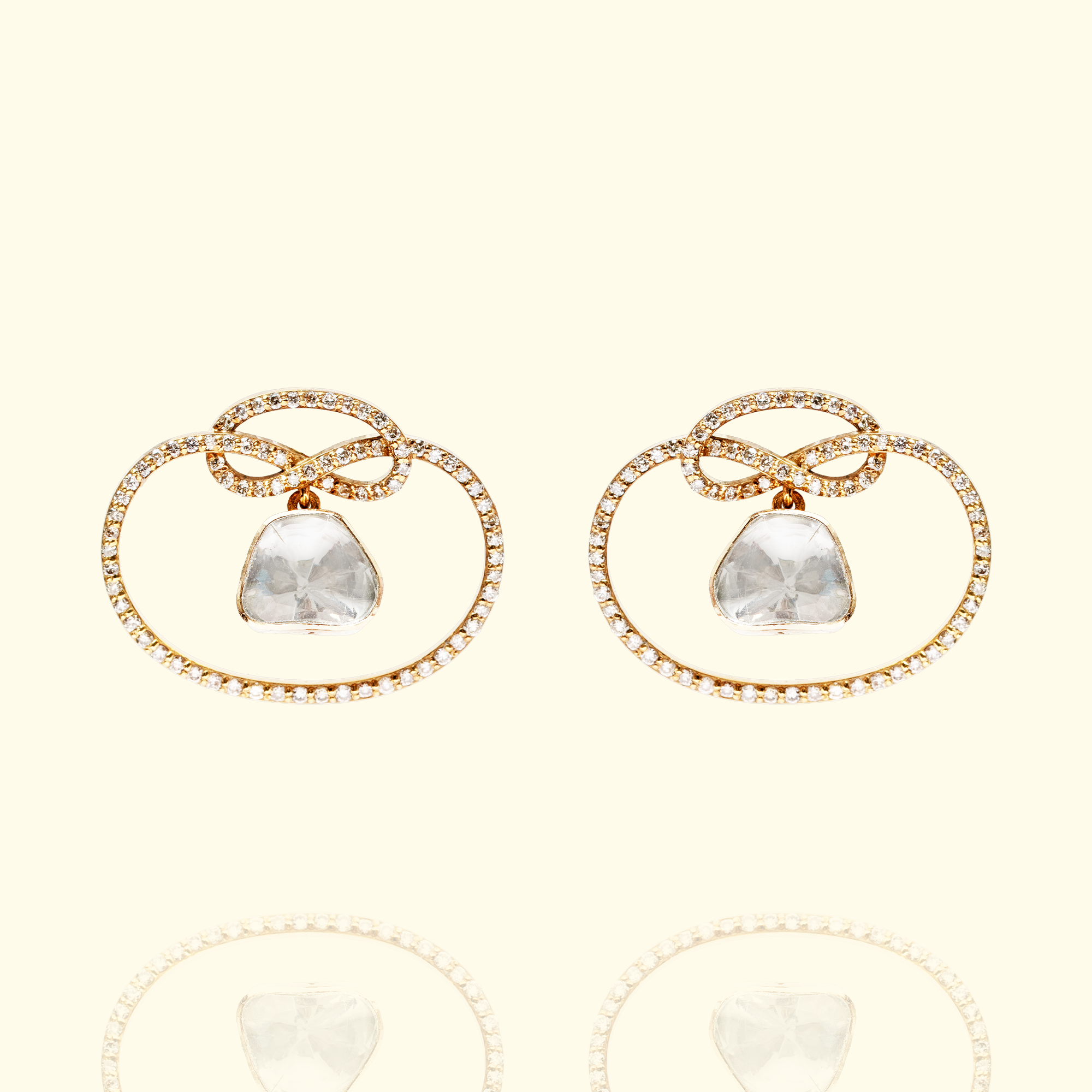 Pair of gold Polki diamond hoop stud earrings featuring a central uncut diamond and a delicate bow-shaped gold wire frame set with pavé brilliant cut diamonds.