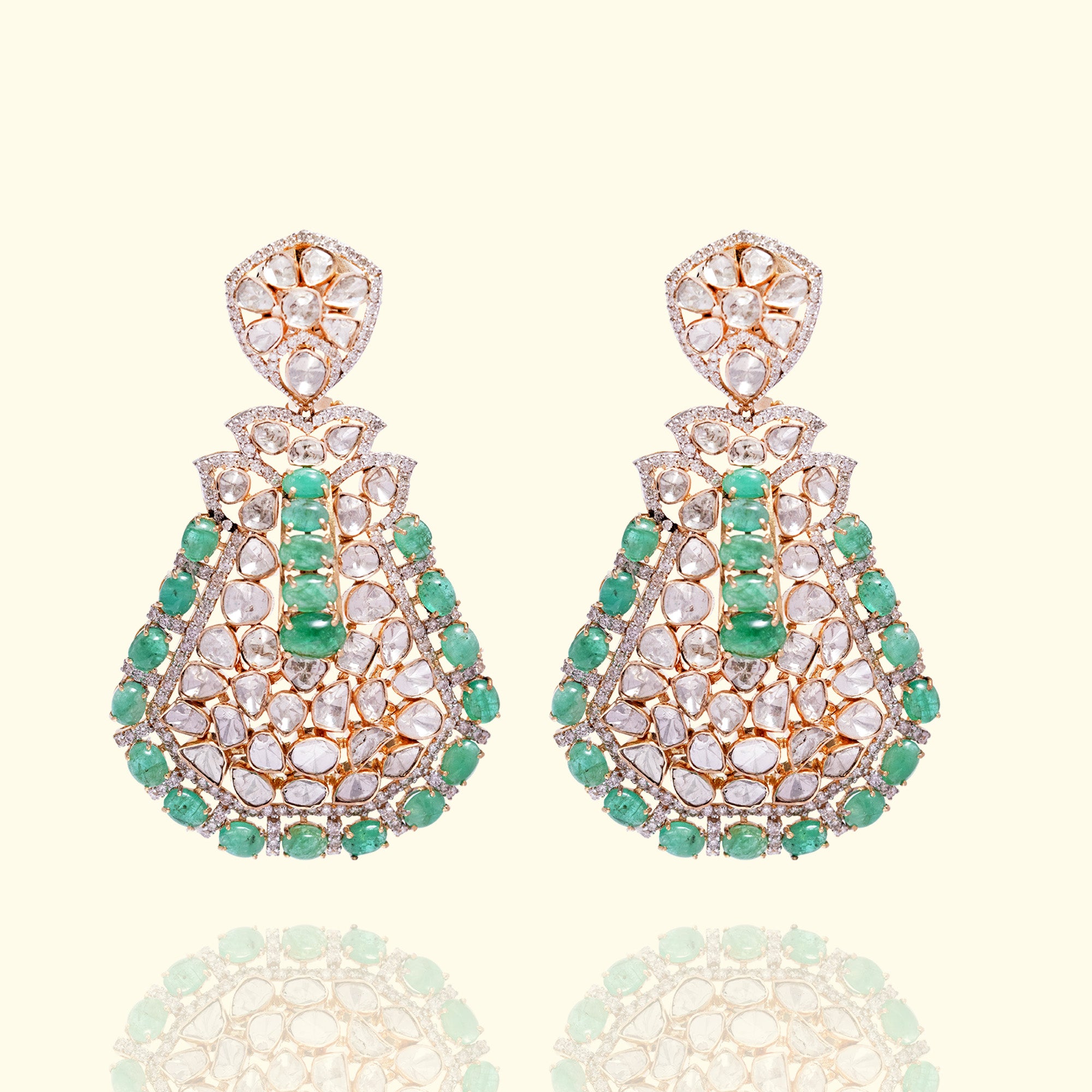 Large gold Polki statement earrings featuring a complex lattice of uncut diamonds and a vertical row of emerald with an vibrant border of emerald bead fringe.