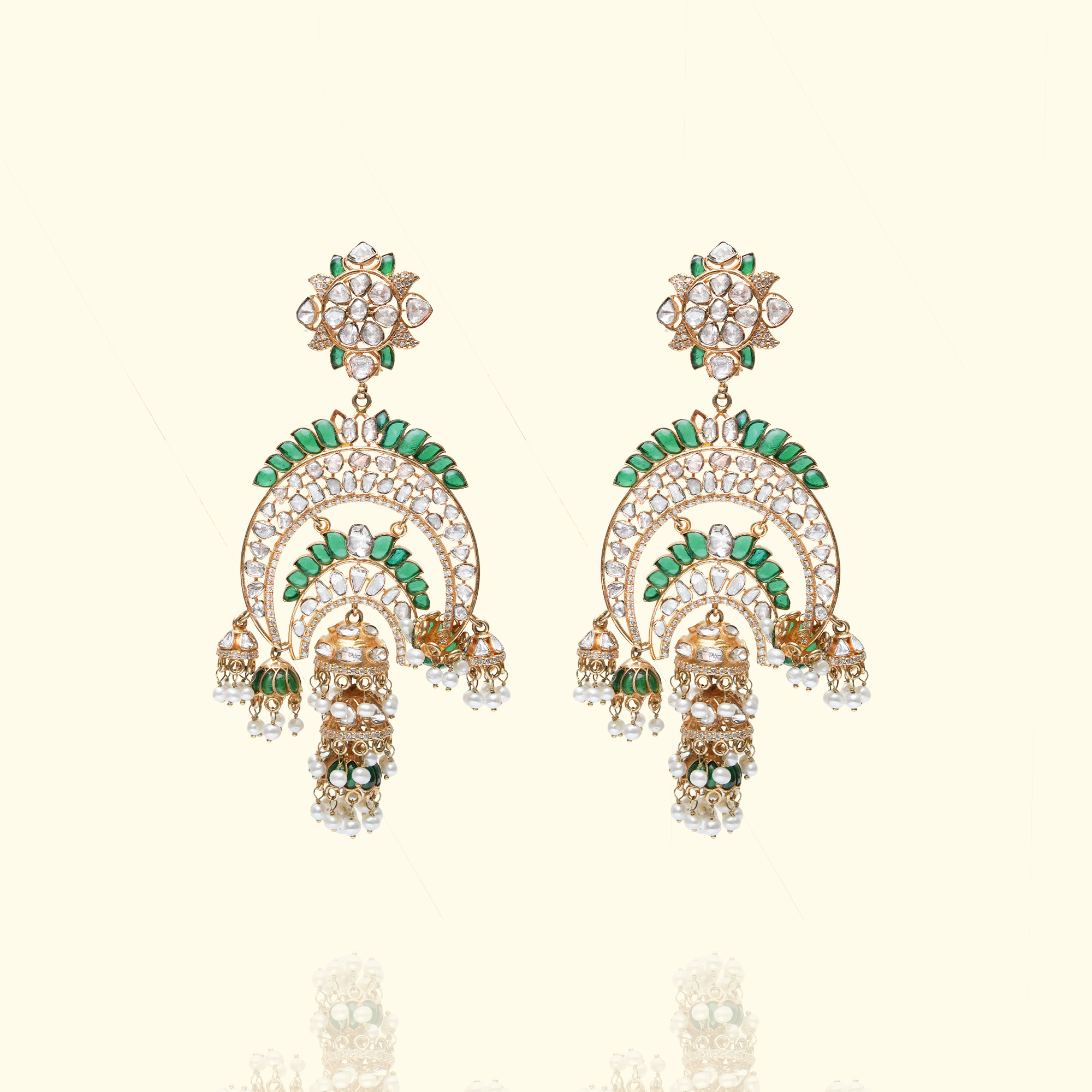 A pair of elaborate gold chandbali earrings featuring floral polki studs, intricate crescent tiers lined with vibrant green enamel, and finished with dangling japanese freshwater pearls and bell-shaped jhumka charms.