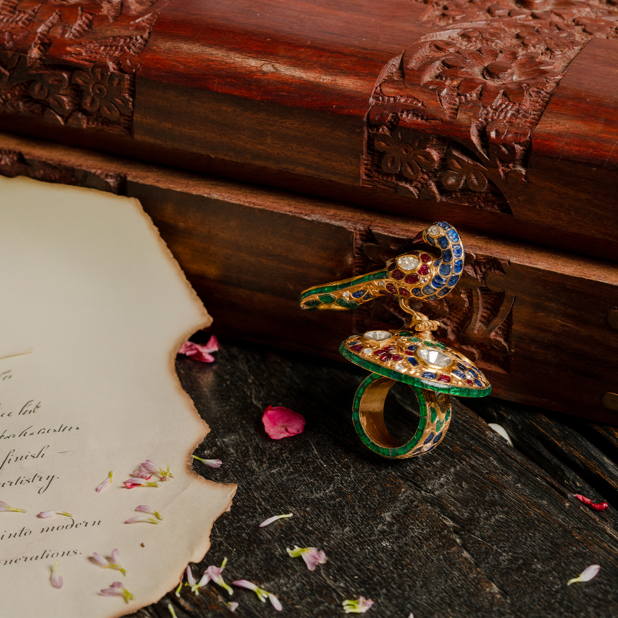 An extraordinary 3D peacock statement ring crafted in gold polki and adorned with vibrant blue, green, and red enamel and polki diamonds.