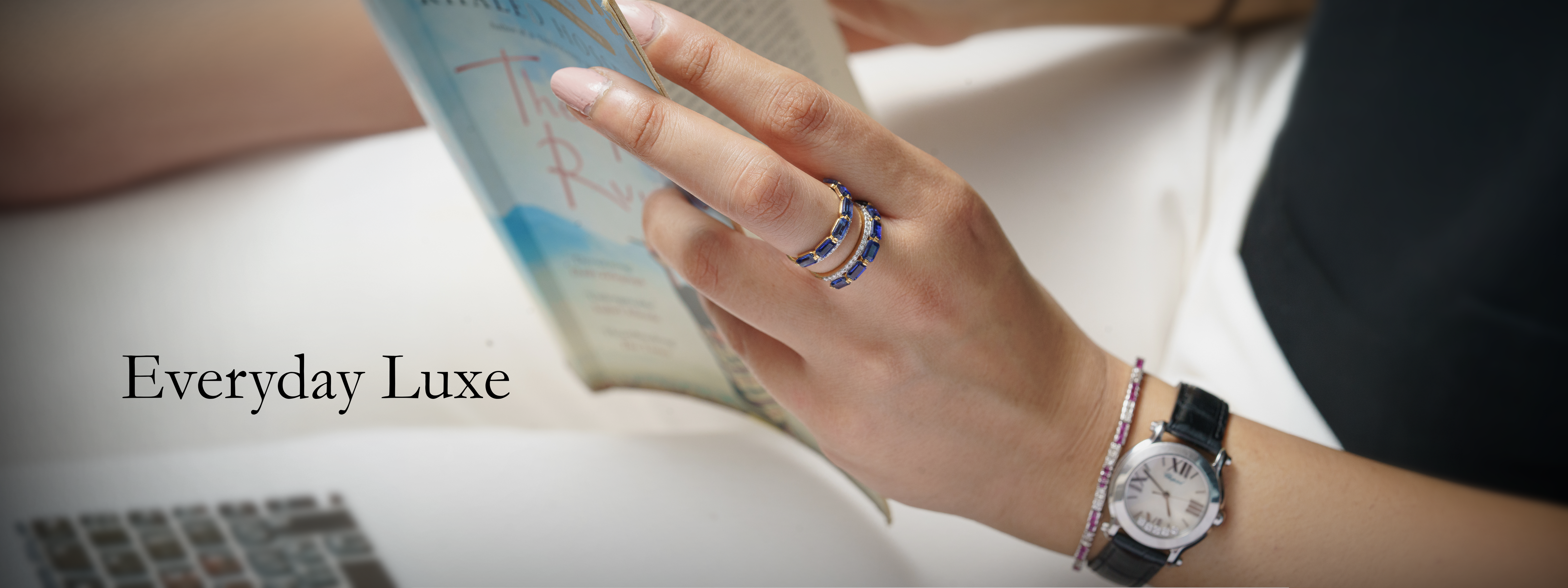 Person holding a book with a watch on wrist, 'Everyday Luxe' text visible