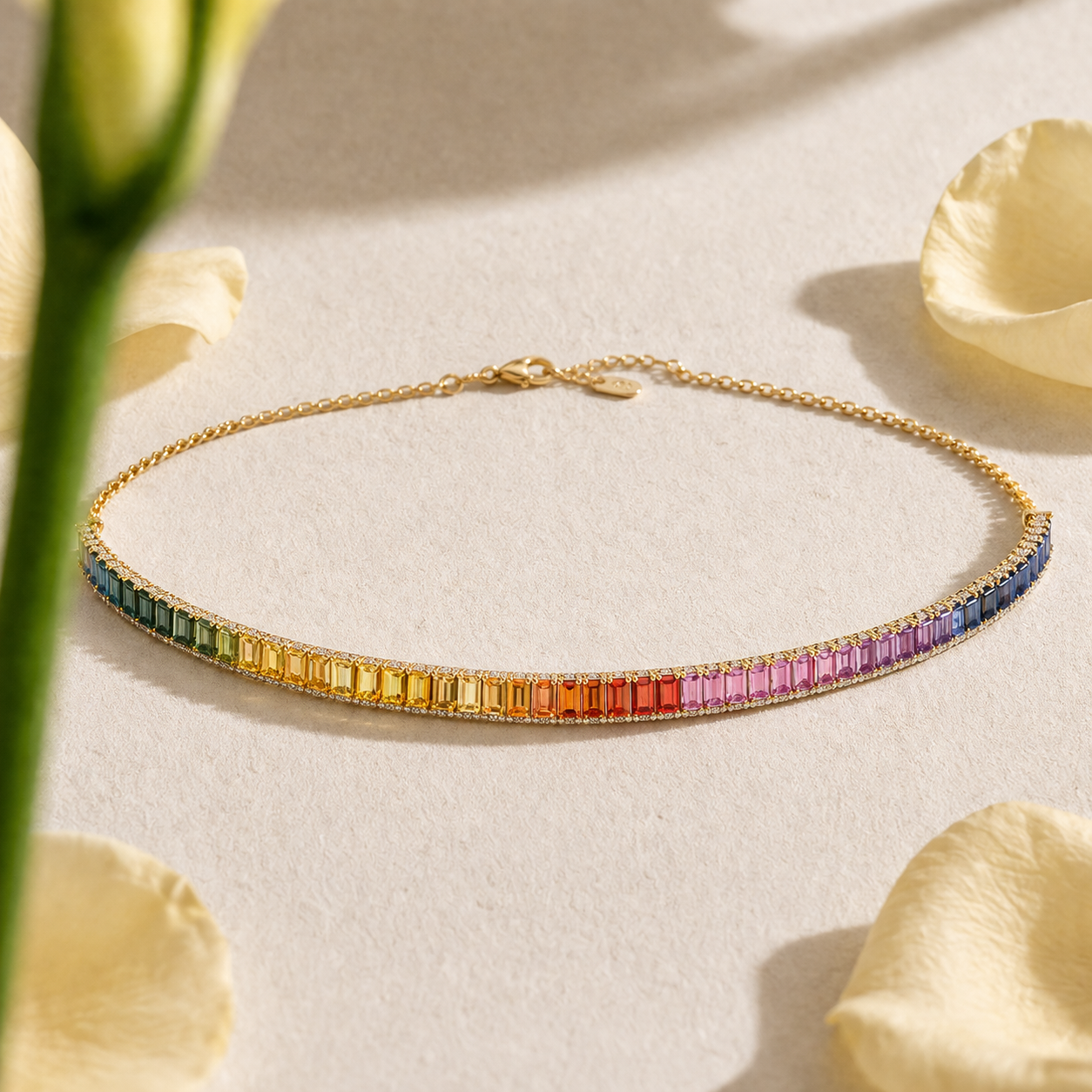 Gold necklace with colorful gemstones on a light surface with flowers in india