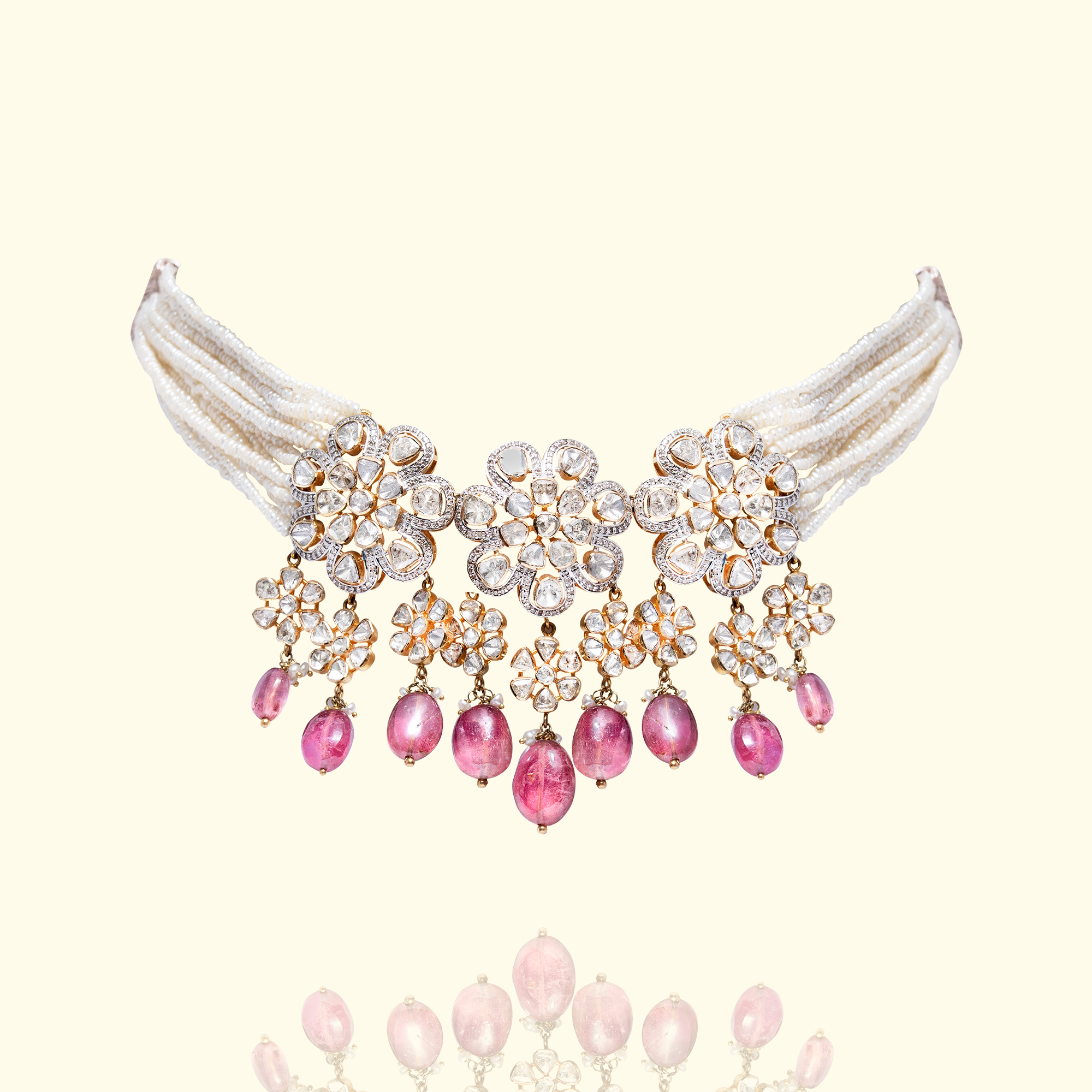 Ornate gold multi-strand japanese freshwater pearl choker necklace featuring three floral Polki diamond centers and dangling ruby gemstone droplets.