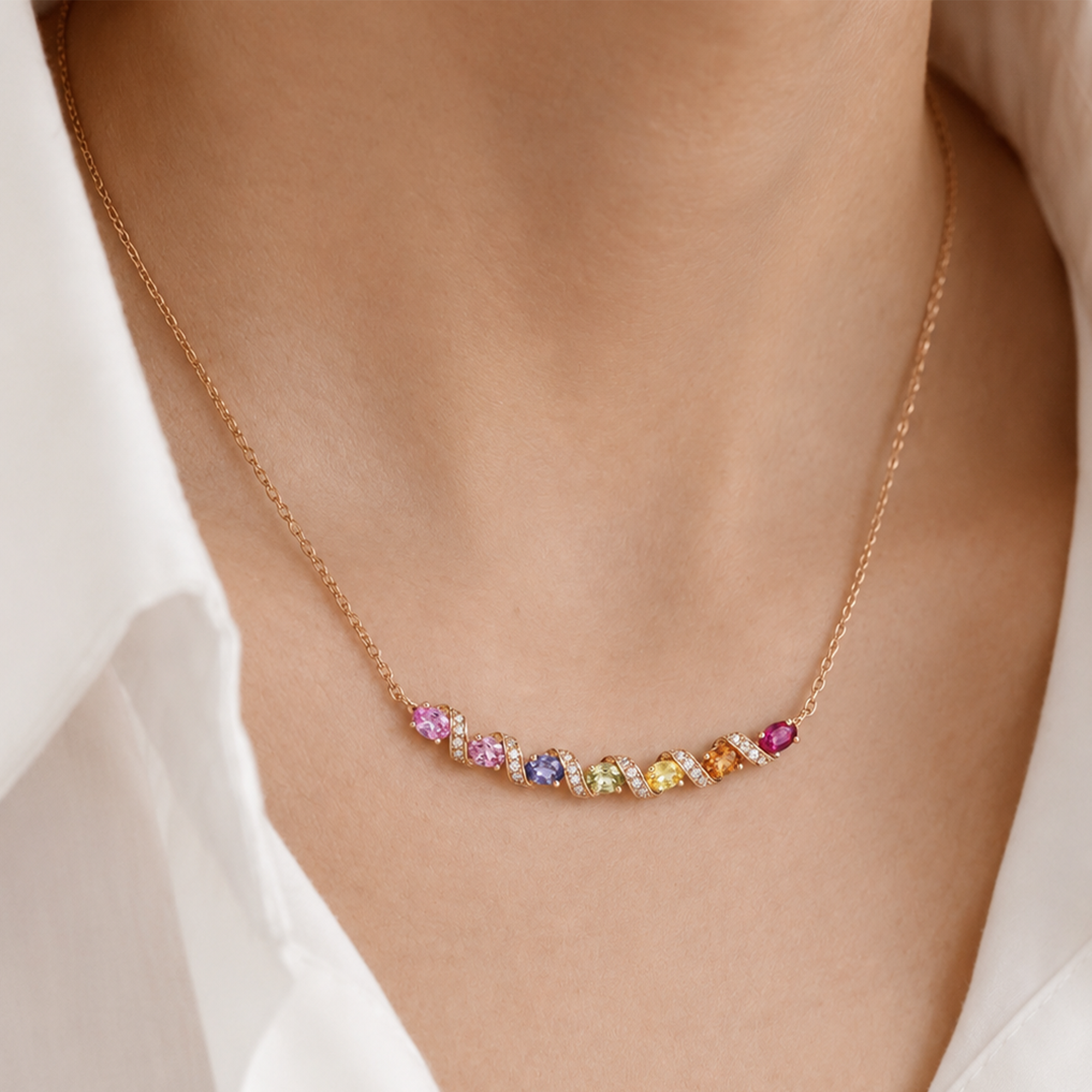 Necklace with multicolored gemstones on a person wearing a white shirt in india