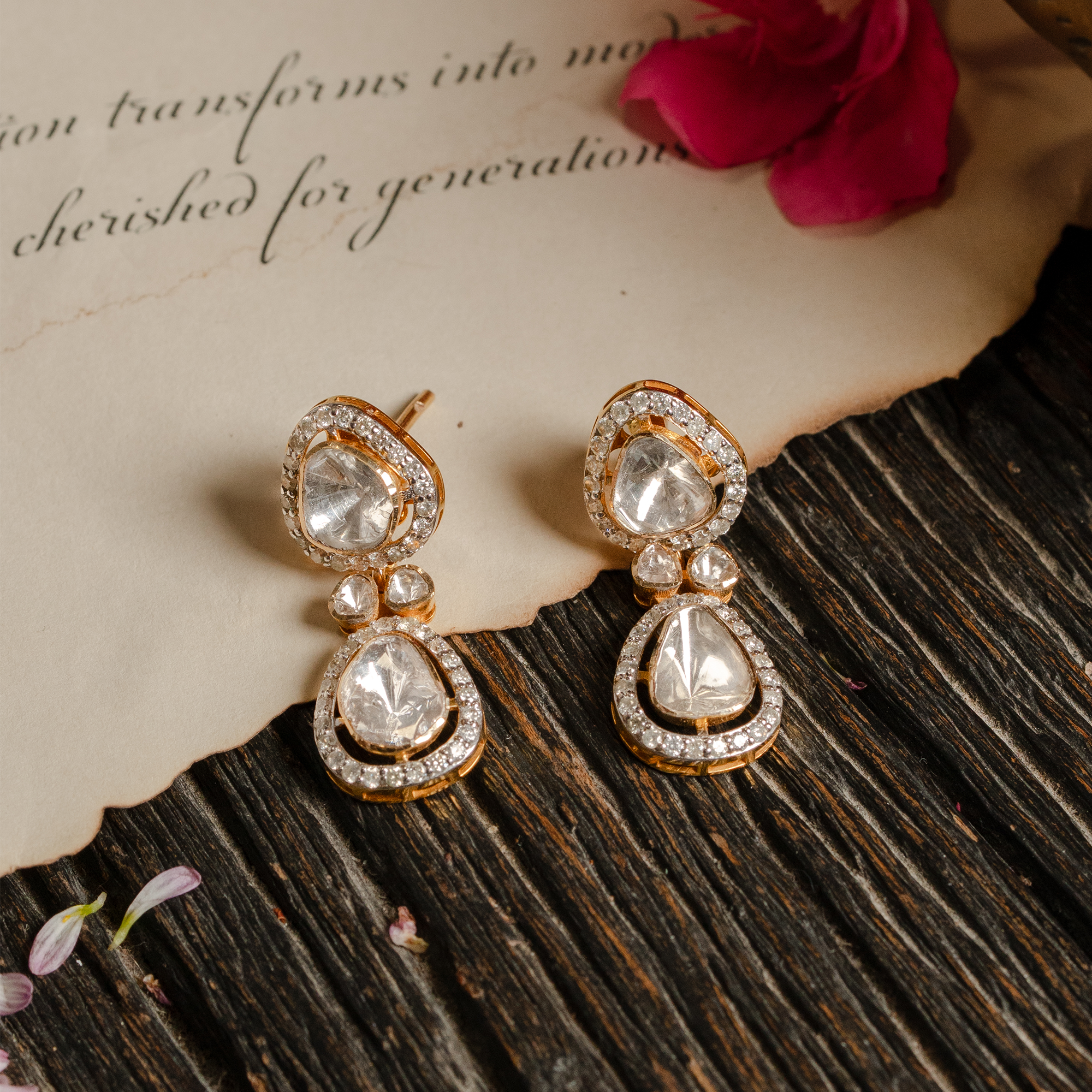 A pair of elegant double-drop earrings featuring two tiers of pear-shaped polki diamonds, each framed by a shimmering pavé diamond halo in india
