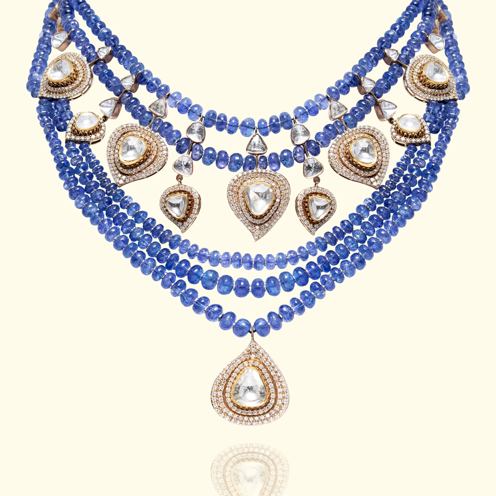 High-jewelry multi-strand tanzanite bead necklace featuring dangling pear-shaped Polki diamond charms in ornate gold settings in india