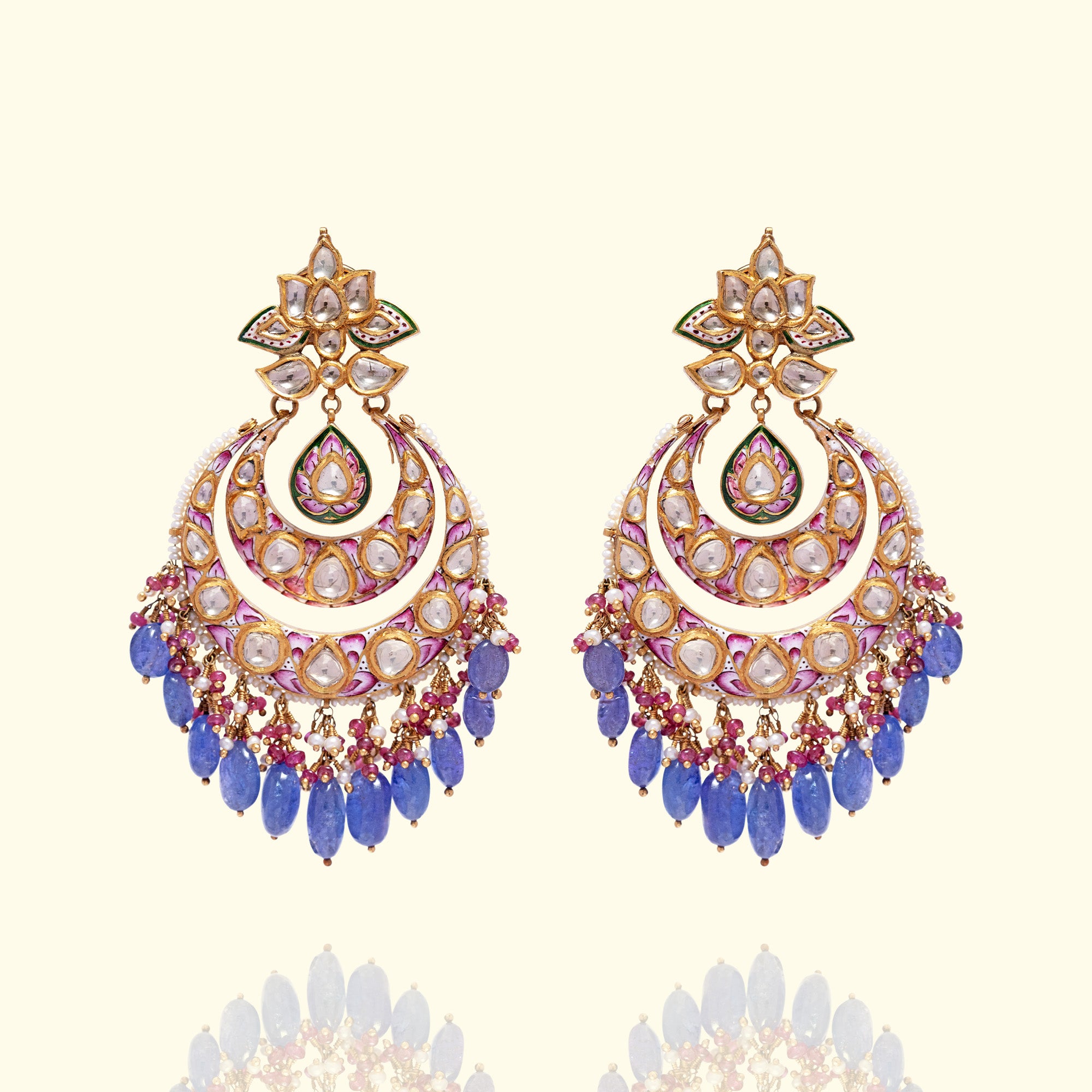 A pair of ornate gold polki crescent-shaped earrings featuring pink and white floral meenakari enamel work and uncut diamond settings, finished with a lush fringe of tanzanite bead drops and japanese freshwater pearls.