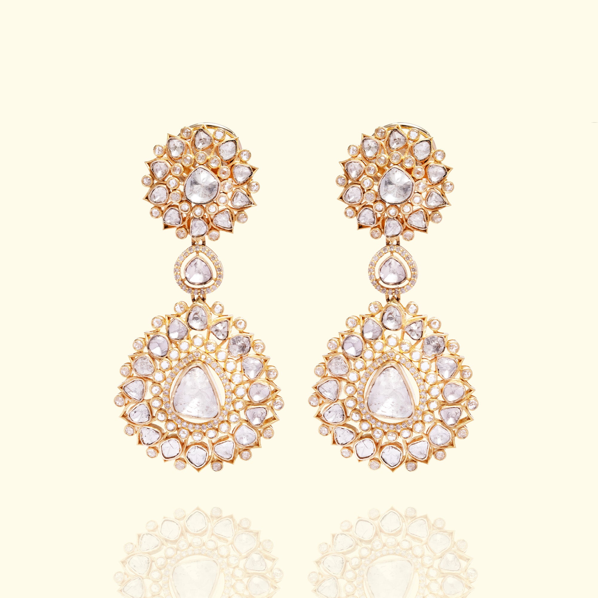 A pair of high-jewelry gold polki earrings featuring intricate floral polki studs and large, tiered circular dangles encrusted with graduated uncut diamonds.