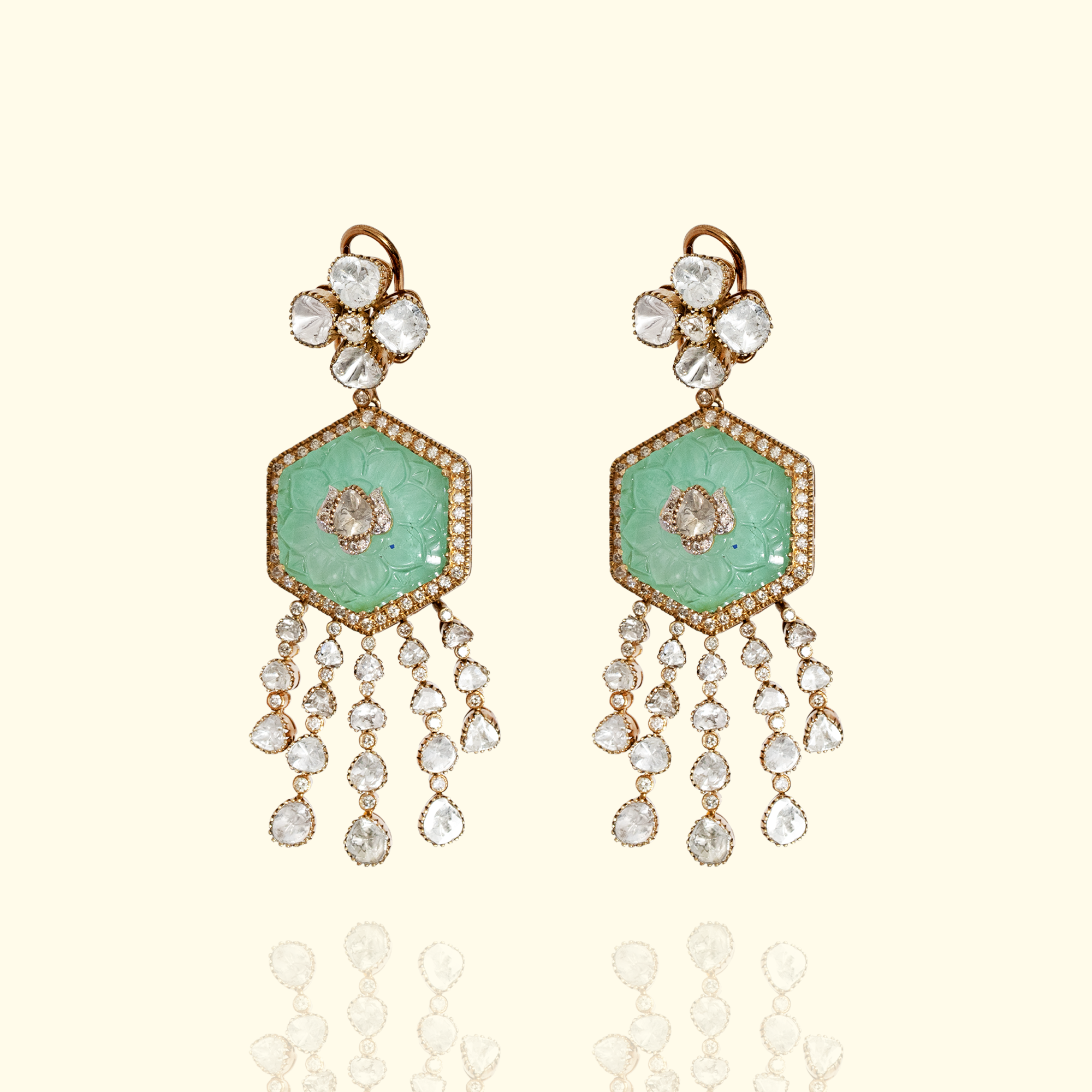 Pair of gold Polki and emerald earrings featuring a carved hexagonal emerald centerpiece and multi-strand polki diamond dangles.