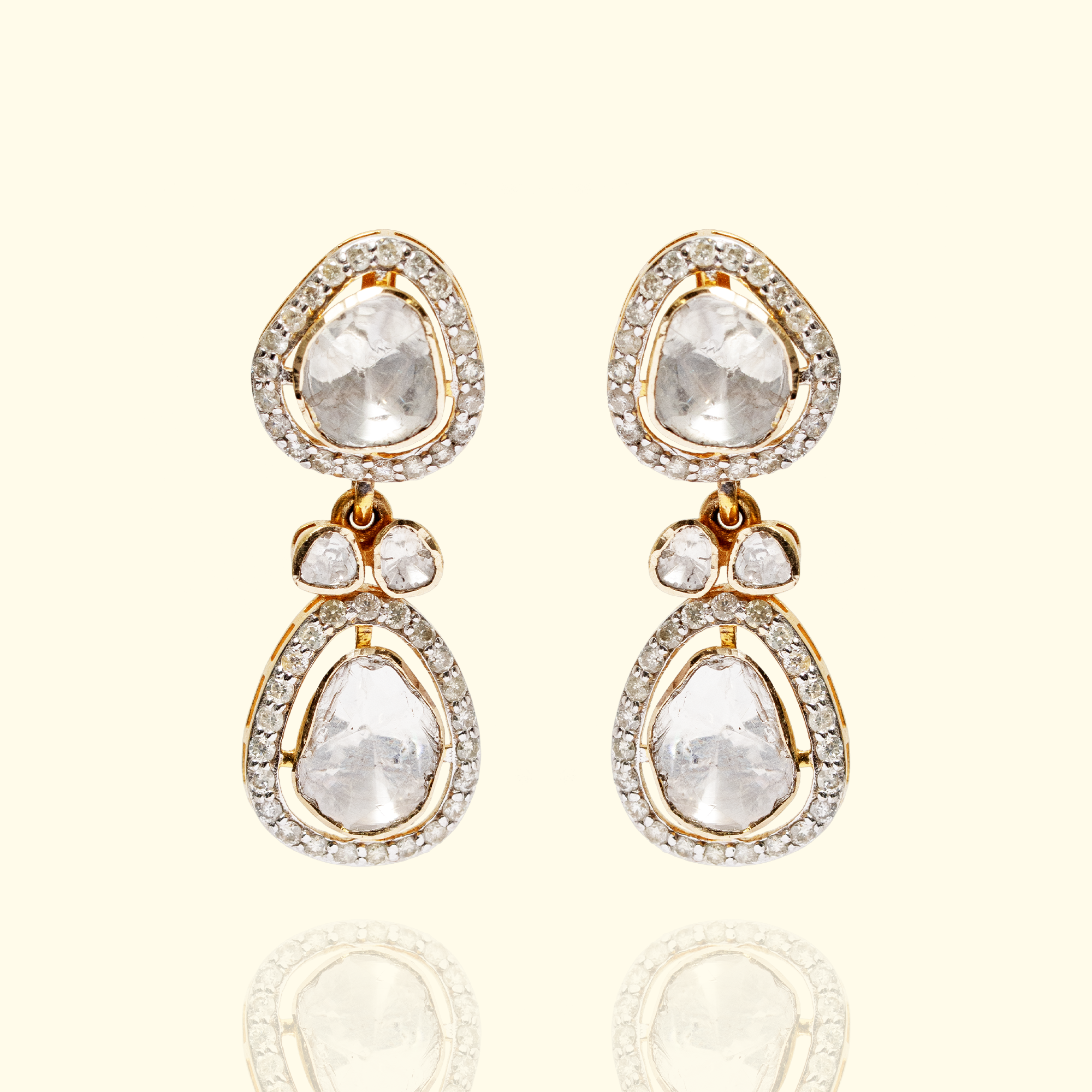 Pair of gold Polki diamond drop earrings featuring two tiers of organic-shaped uncut diamonds surrounded by a brilliant-cut diamond pave halo.