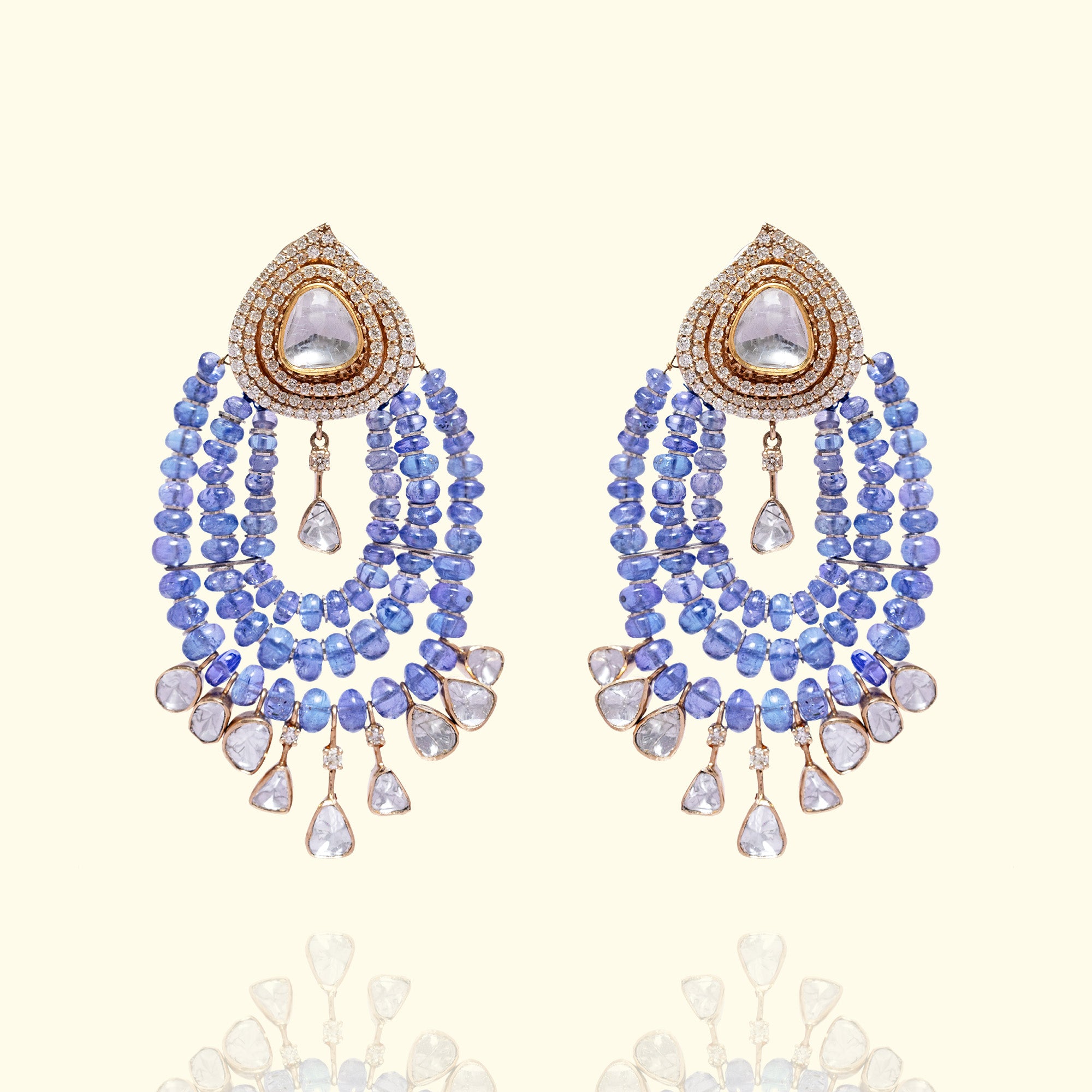 A pair of ethereal blue tanzanite chandelier earrings featuring pear-shaped polki diamond studs and cascading multi-strand tanzanite bead swags finished with delicate diamond charms.
