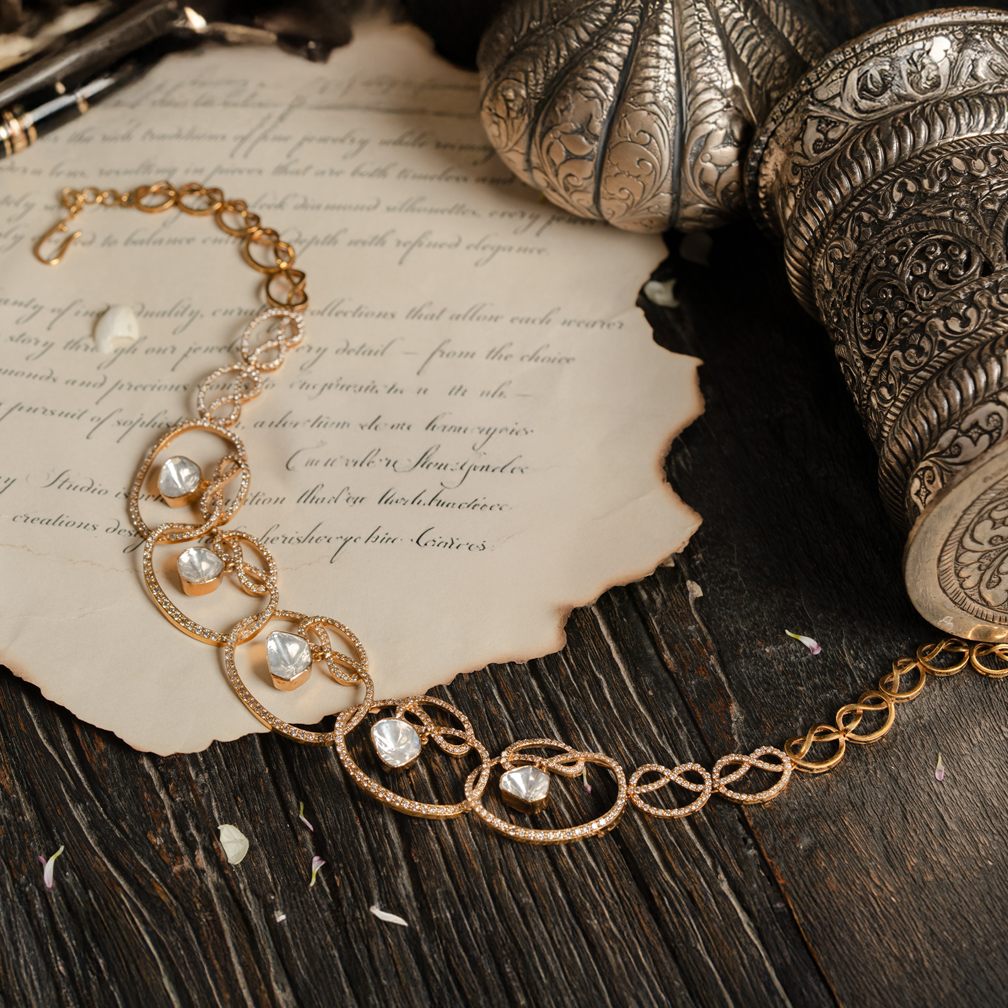 A contemporary gold polki necklace featuring a sequence of interlocking infinity-style loops encrusted with shimmering pavé diamonds, each framing a central, bezel-set triangular uncut diamond.