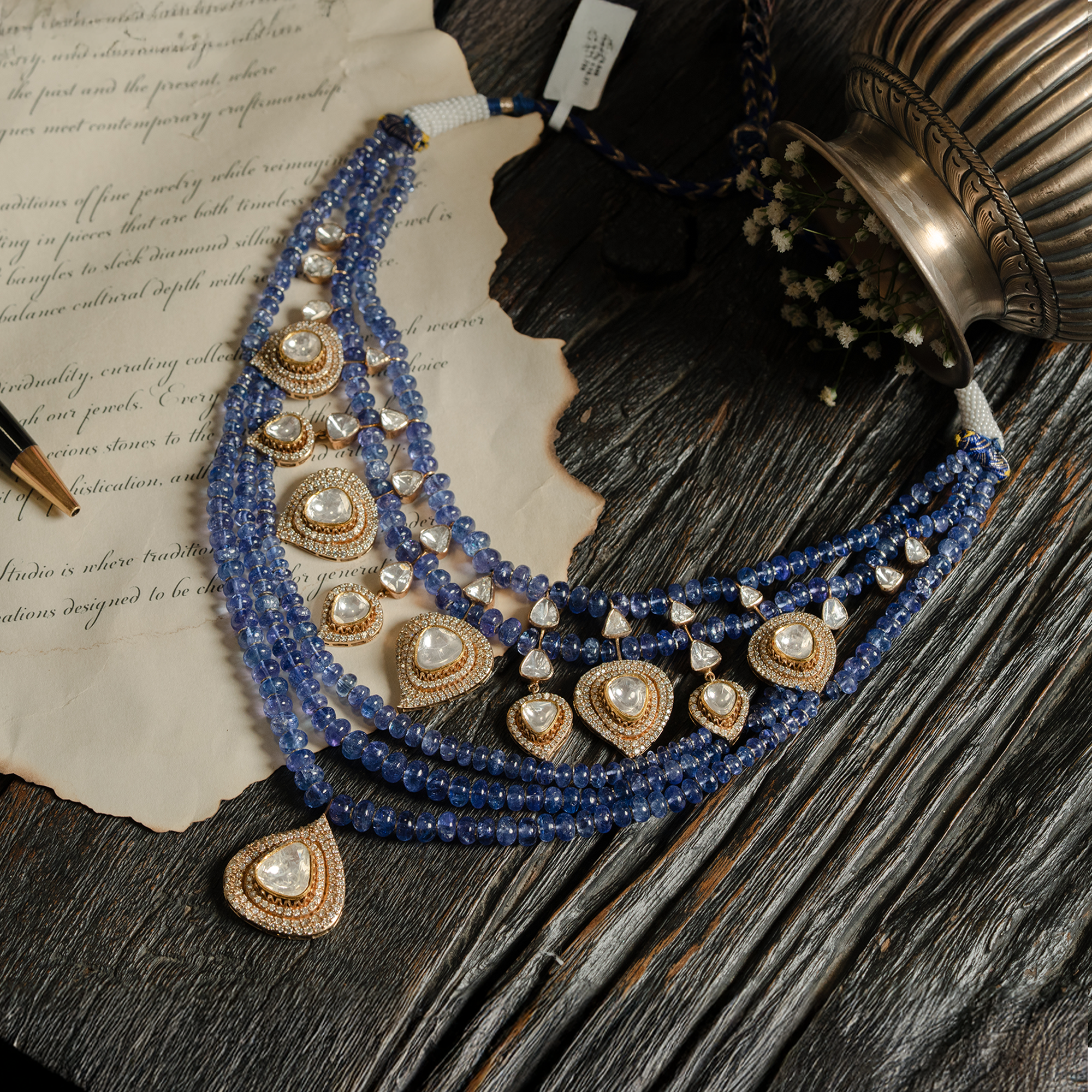 A magnificent multi-strand tanzanite bead necklace featuring graduated rows of blue-violet beads and multiple pear-shaped polki diamond pendants set in shimmering halos.
