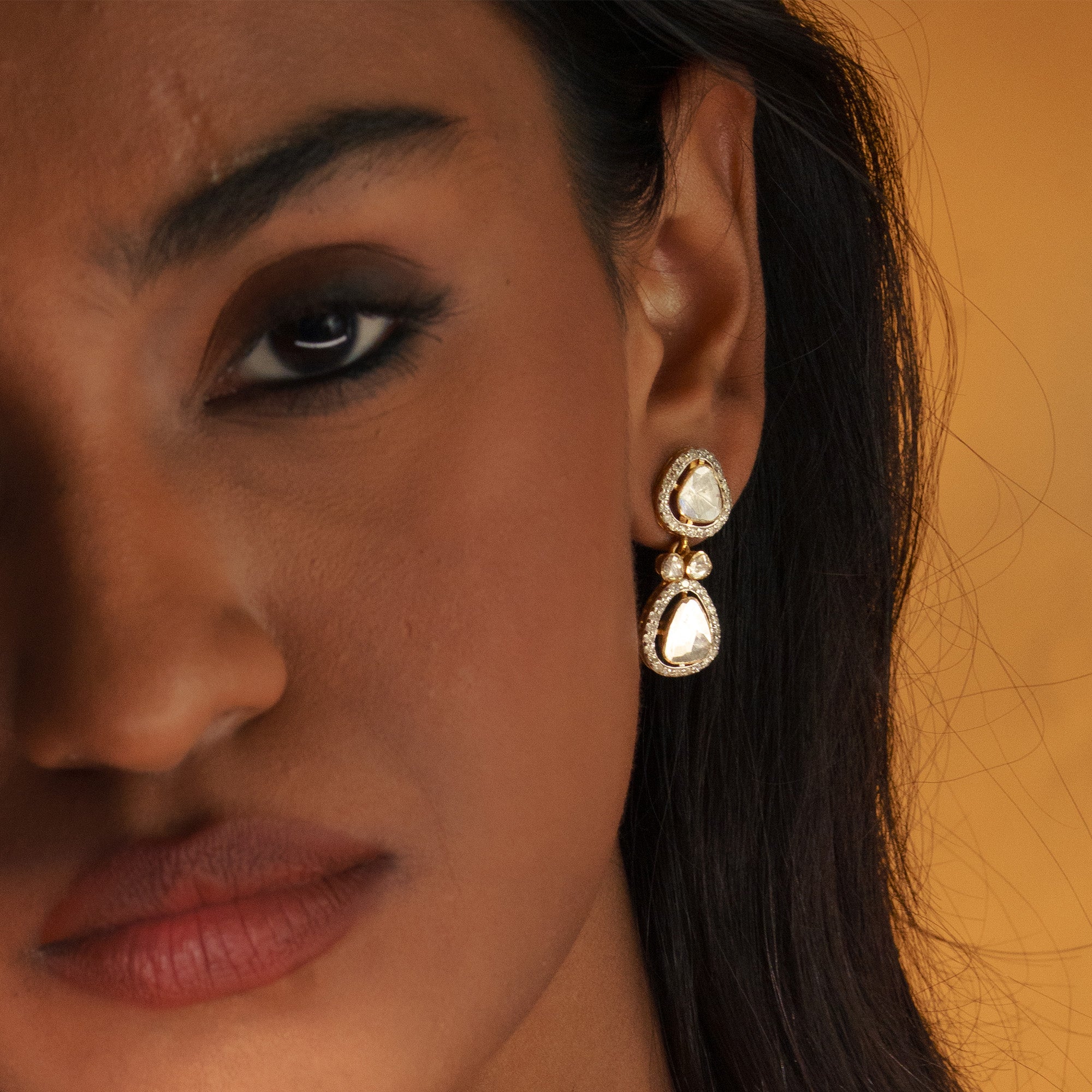 Pair of gold Polki diamond drop earrings featuring two tiers of organic-shaped uncut diamonds surrounded by a brilliant-cut diamond pave halo.