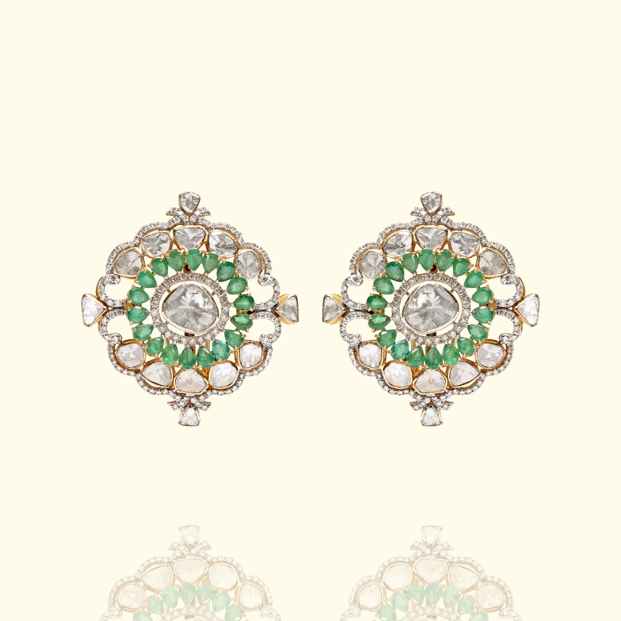 A pair of sophisticated floral-motif earrings featuring a central polki diamond framed by a double halo of pear-cut emeralds and pavé diamonds in india