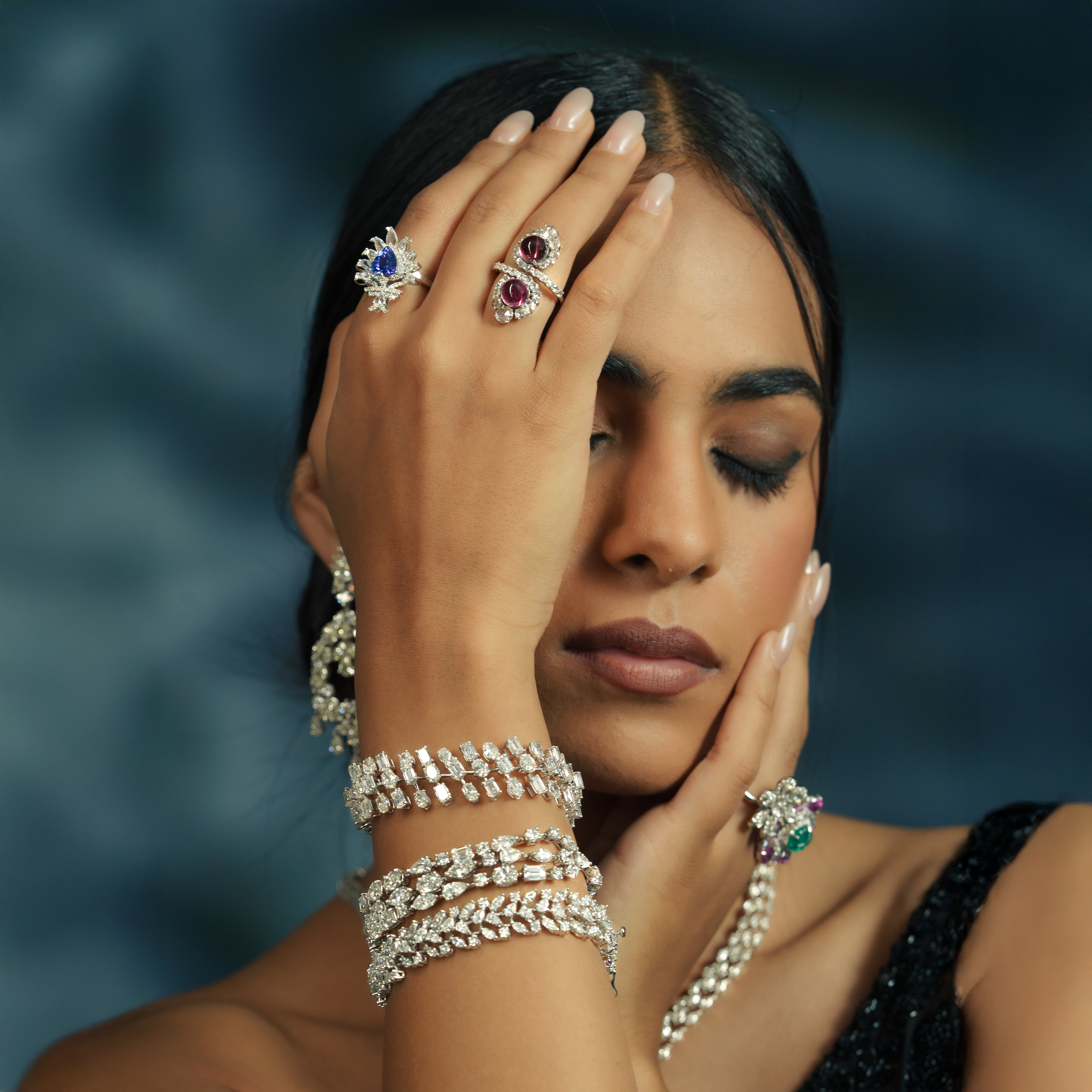 Detailed view of tiered diamond bracelet and a vibrant blue sapphire and ruby teardrop ring, showcasing high-end bridal diamond craftsmanship.